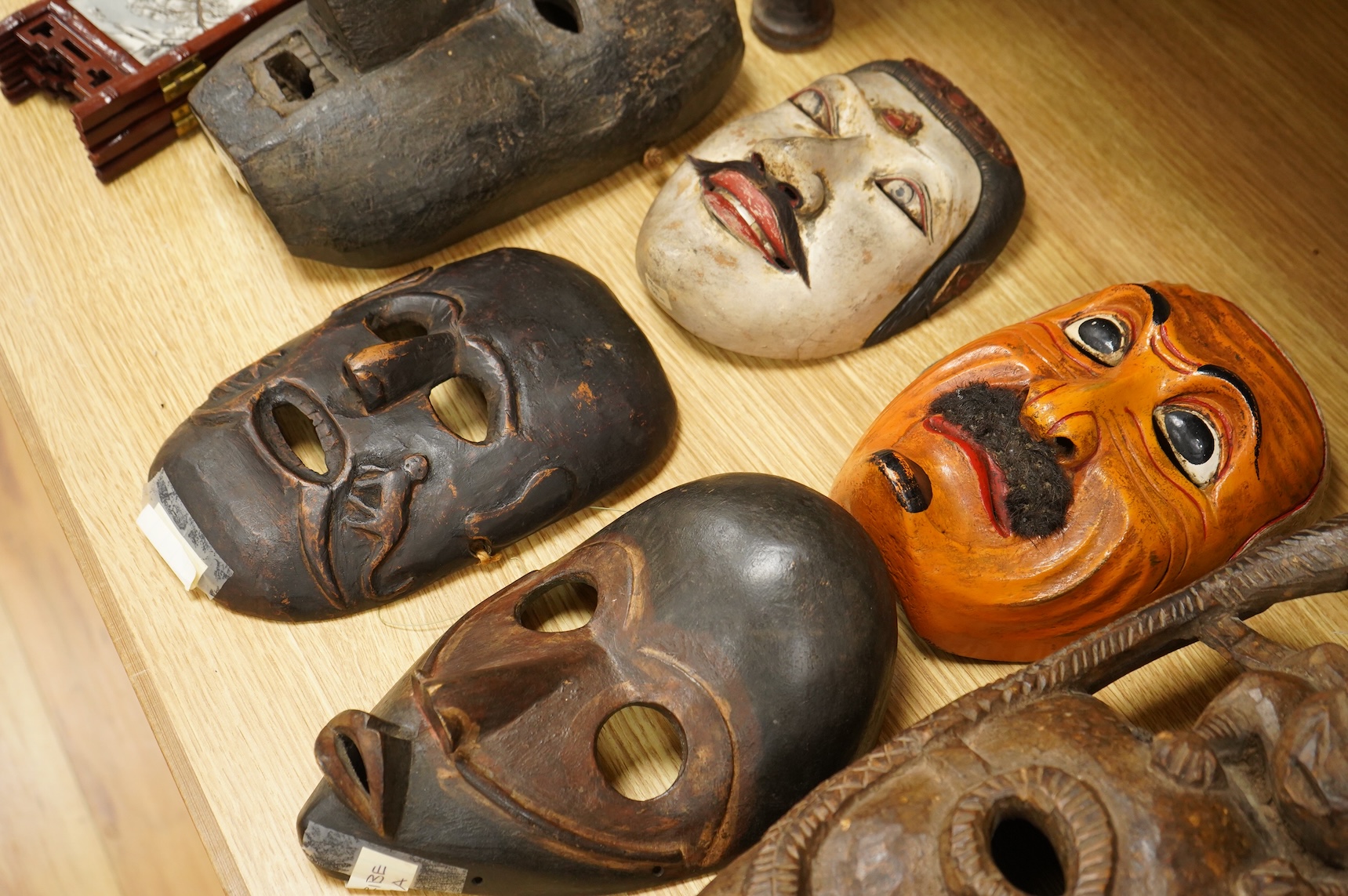 A collection of seven Nepalese, African and Indonesian masks to include a Magar example and one from the Dan Tribe, Liberia, largest 40cm